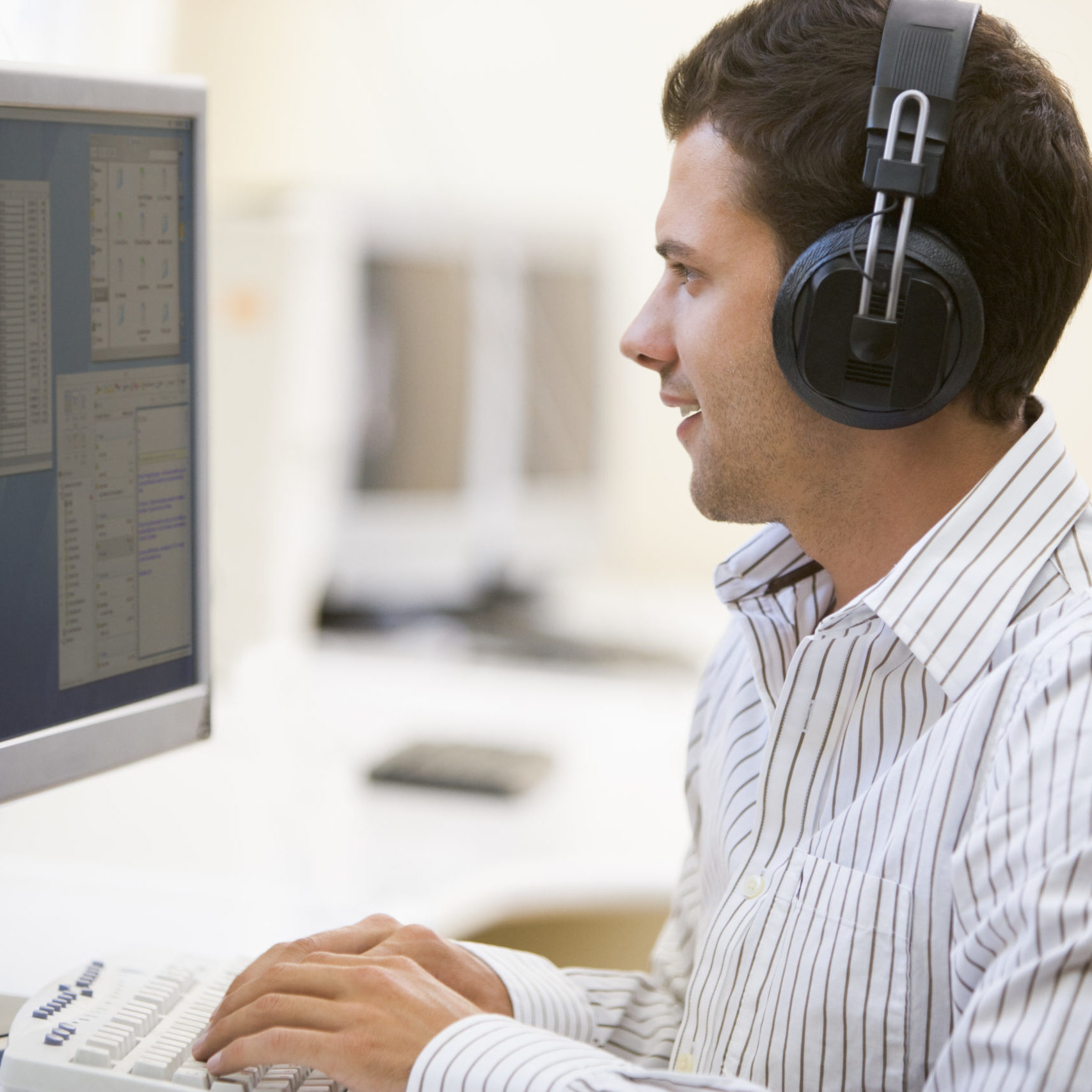 Man wearing headphones while working in front of a computer